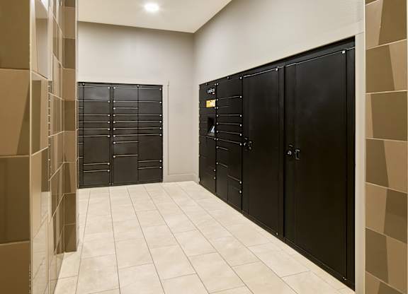 A hallway with black doors and a tiled floor.