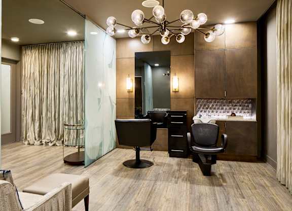 A modern office with a glass wall and a wooden floor.