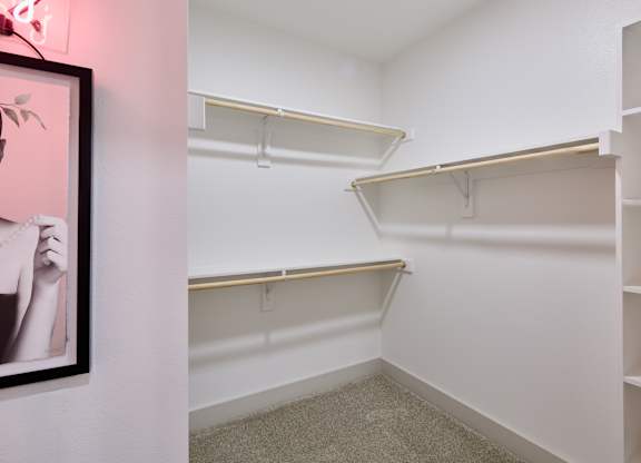 A room with a pink neon sign and a framed picture on the wall.