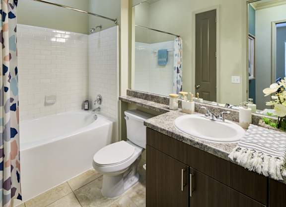 A bathroom with a white toilet, a white sink, and a white bathtub.