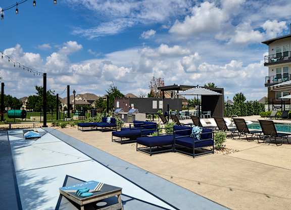 A pool area with lounge chairs and umbrellas.