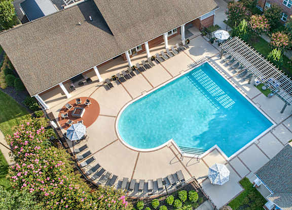 A large swimming pool surrounded by a patio and a deck.