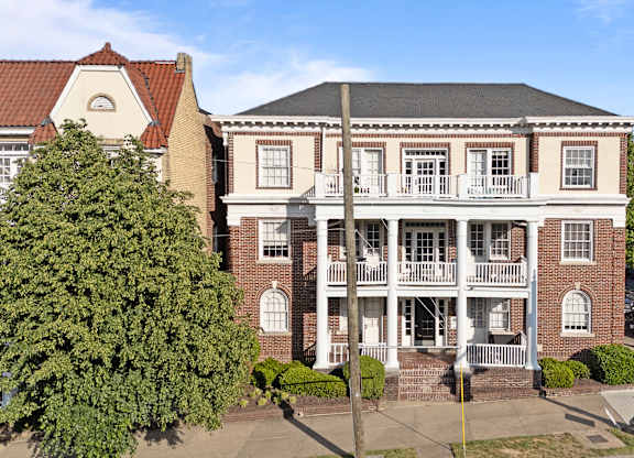 A large red brick building with a balcony in the middle.