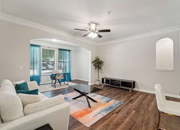 A living room with a white sofa, a coffee table, and a rug.