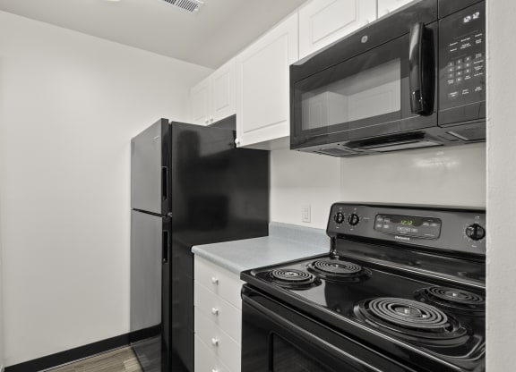 Kitchen with white cabinetry and black appliances at Creve Coeur, Creve Coeur, MO