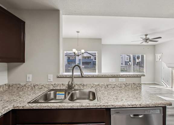 A kitchen with a granite countertop and stainless steel appliances at Sweetwater At Metro North Apartments, Arizona