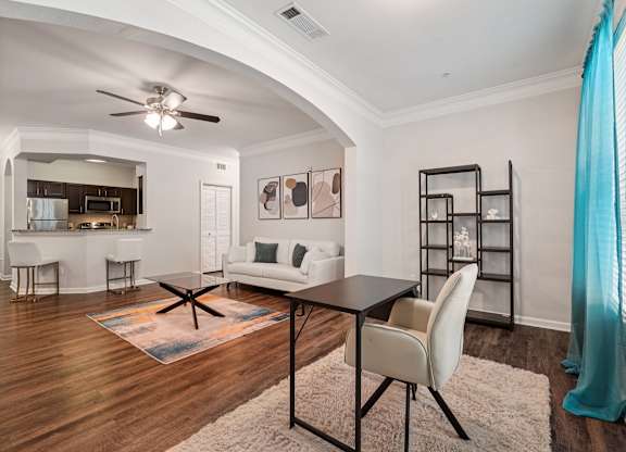 A modern living room with a black table and white chairs.