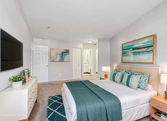 A bedroom with a bed, nightstand, and a painting on the wall. at Millennium at Creve Coeur, Missouri, 63141