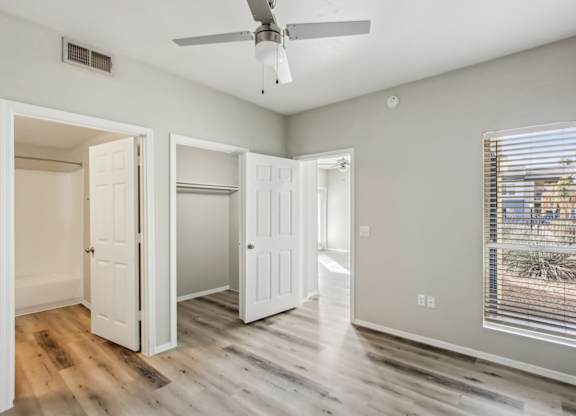A room with a ceiling fan and a window with blinds at Sweetwater At Metro North Apartments, Arizona