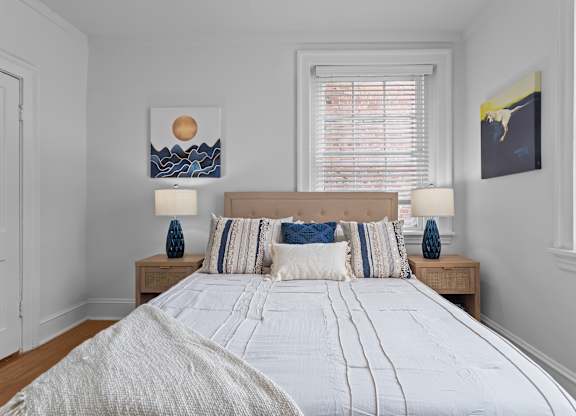 A bedroom with a large bed and two lamps on side tables.