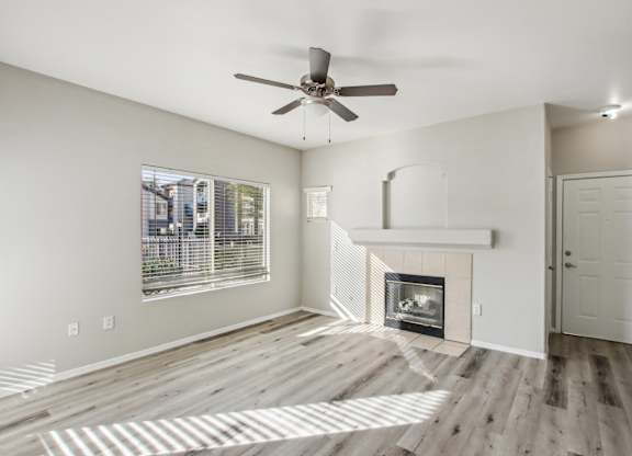 A room with a fireplace and a ceiling fan at Sweetwater At Metro North Apartments, Phoenix  85029