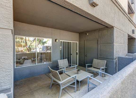 A patio with a table and chairs is on the balcony of a building at Sweetwater At Metro North Apartments, Phoenix