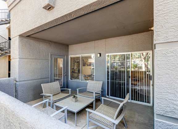 A patio with a table and chairs is on the balcony of a house at Sweetwater At Metro North Apartments, Phoenix, Arizona