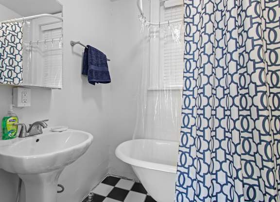 A white sink with a green bottle of soap on it.