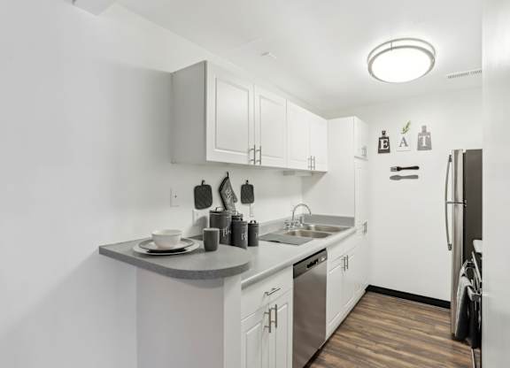 A kitchen with white cabinets and a wooden floor. at Millennium at Creve Coeur, Missouri, 63141
