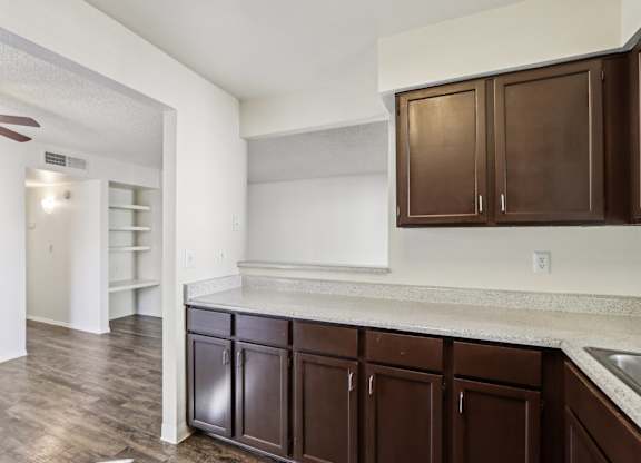 A kitchen with brown cabinets and a white counter.