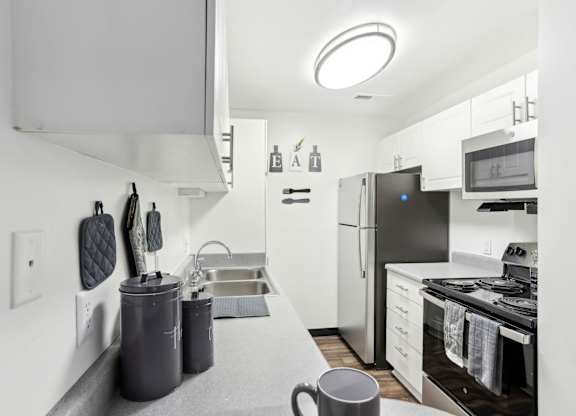 A modern kitchen with a grey countertop and stainless steel appliances. at Millennium at Creve Coeur, Missouri, 63141
