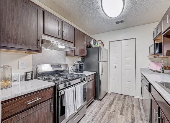 a kitchen with wood cabinets and stainless steel appliances at St. Johns Forest Apartments, Florida, 32277