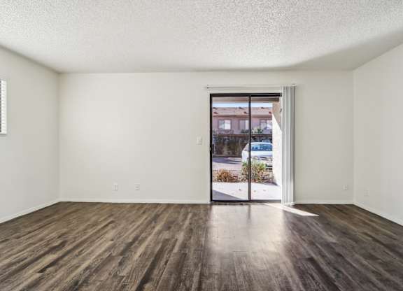 A room with a sliding glass door leading to a street.