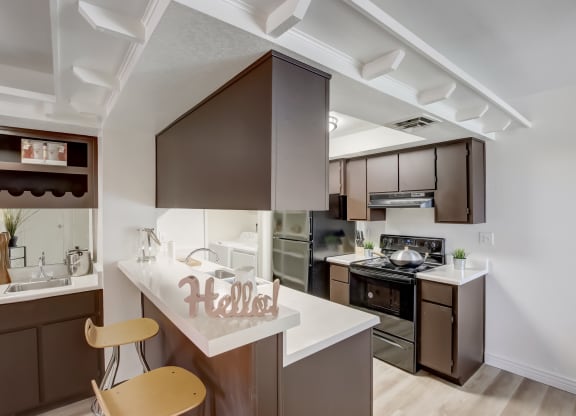 a kitchen with brown cabinets and white countertops at Glen at Mesa Apartments, AZ 85201