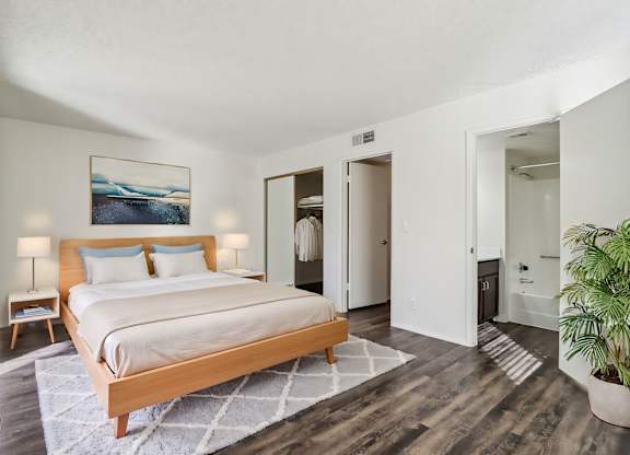 A bedroom with a large bed and a painting on the wall.