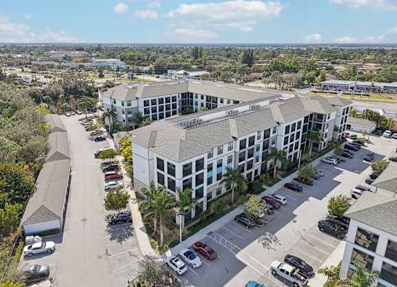 A large white building with a parking lot in front of it.
