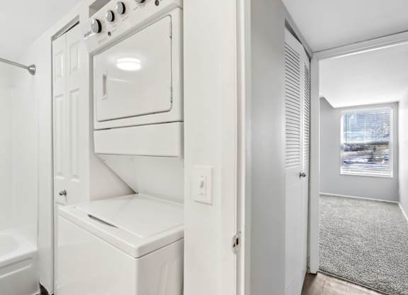 A white oven and microwave are built into a wall in a kitchen. at Millennium at Creve Coeur, Missouri