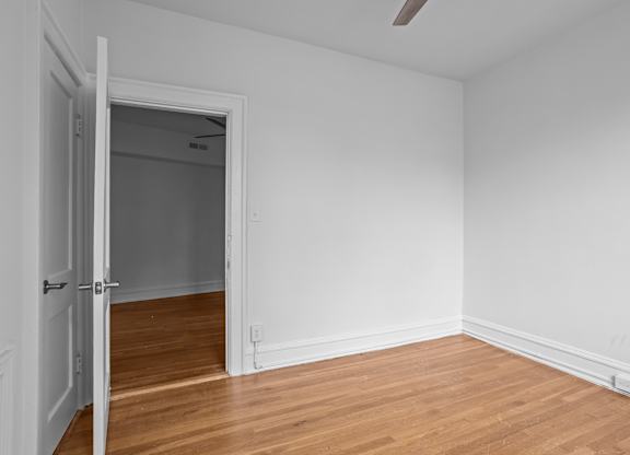 A room with a wooden floor and a white door.