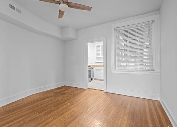 A room with a wooden floor and a ceiling fan.