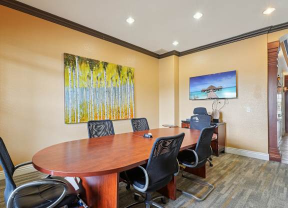 A conference room with a large table and chairs.
