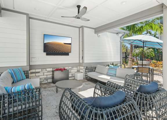 A patio with a television and outdoor furniture.