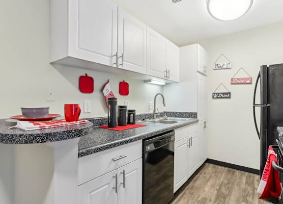 A kitchen with white cabinets and a black refrigerator. at Millennium at Creve Coeur, Creve Coeur, 63141