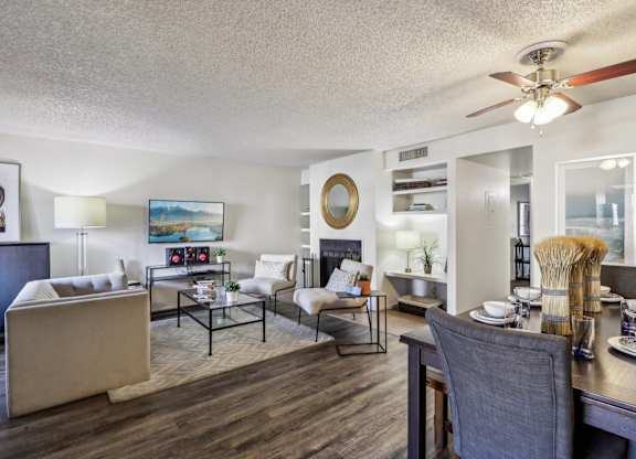 A well-lit living room with a dining area in the background.