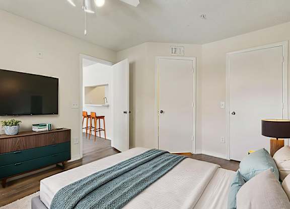 A bedroom with a large bed and a flat screen TV.