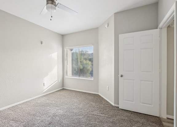 A room with a ceiling fan and a door. at Sweetwater At Metro North Apartments, Arizona 85029