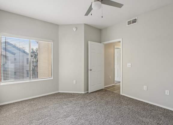 A room with a ceiling fan and a window with blinds at Sweetwater At Metro North Apartments, Phoenix, AZ 85029