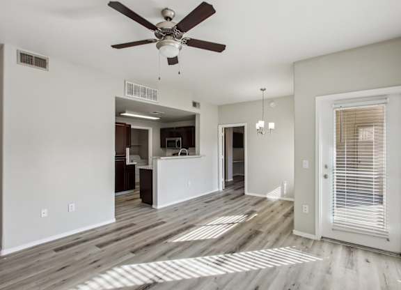 A room with a ceiling fan and wooden flooring at Sweetwater At Metro North Apartments, Phoenix