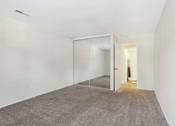 A room with a carpeted floor and a glass door. at Millennium at Creve Coeur, Creve Coeur
