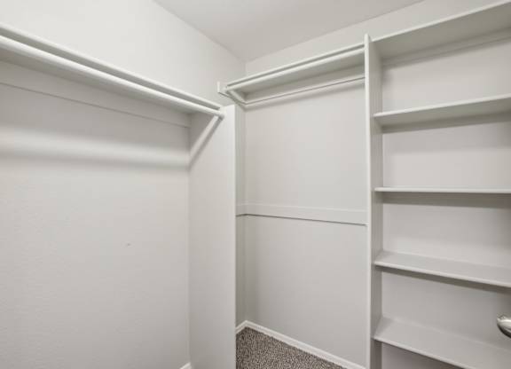 A white closet with shelves and a carpeted floor at Sweetwater At Metro North Apartments, Phoenix, AZ