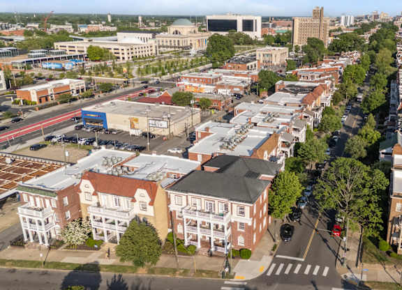 A city street with buildings on either side and cars parked on the side of the road.