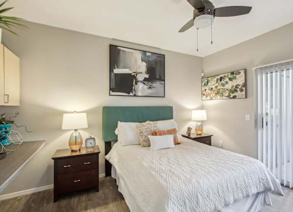 A bedroom with a bed, nightstands, and a ceiling fan at Sweetwater At Metro North Apartments, Phoenix, Arizona