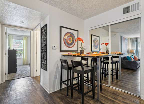 A dining room with a wooden table and chairs.