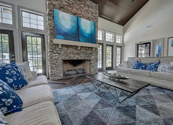 a living room with couches and a coffee table in front of a fireplace at St. Johns Forest Apartments, Florida, 32277