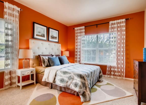 an orange bedroom with a bed and a window at Heritage at Stone Mountain, Northglenn, CO, 80233