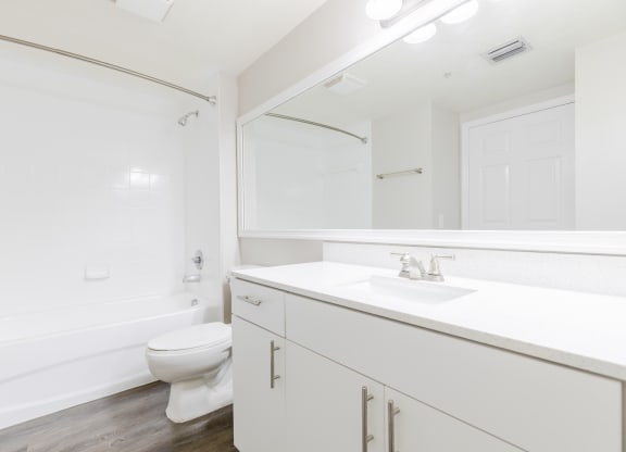 a bathroom with white cabinets and a white toilet at Heritage Bay, Jensen Beach, FL