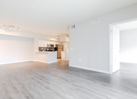 an empty living room with a kitchen in the background at Heritage Bay, Jensen Beach, FL 34957