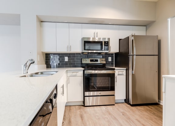 a kitchen with white cabinets and stainless steel appliances at Heritage Bay, Jensen Beach, 34957