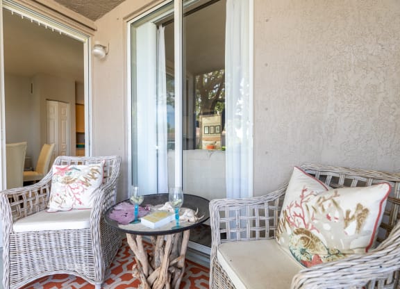 a patio with two wicker chairs and a small table at Heritage Bay, Florida
