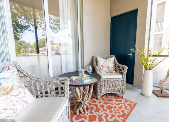 a patio with two chairs and a table at Heritage Bay, Jensen Beach, FL