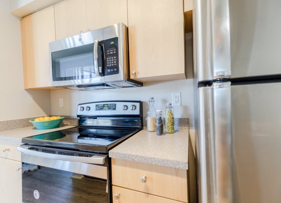 a kitchen with wooden cabinets and stainless steel appliances at Heritage Bay, Jensen Beach, 34957